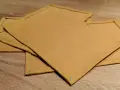 Serviettes de table en tissu ocre, finitions soignées. Idéal pour un tuto serviette de table facile à réaliser.