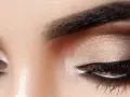Nahaufnahme von Augen mit dezentem, strahlendem Make-up in Gold- und Brauntönen.
