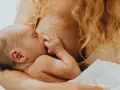Ein Baby wird gestillt. Manchmal, wenn es schreit, fühlt sich die Mutter überfordert, aber hier ist es friedlich.