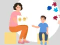 Kobieta z kartką emocji i chłopiec z puzzlami. Dobre rokowania w autyzmie dziecięcym to nadzieja na rozwój.