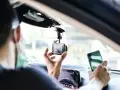 Mann installiert Dashcam im Auto, ADAC-Mitglieder profitieren von sicherer Fahrt.