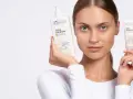 Kobieta prezentuje emulsję i krem Bielenda Cera Lipidum. Produkty z linii linoderm odbudowują barierę lipidową skóry.