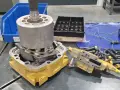 Rozłożone części do naprawy pomp wodnych. Widać elementy hydrauliczne, wał, obudowę i śruby.