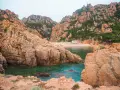 Skaliste wybrzeże Sardynii z turkusową wodą i piaszczystą plażą. Idealne miejsce, by odkryć, co zobaczyć na Sardynii.
