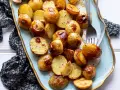 Patate novelle al forno dorate e croccanti, servite su un piatto decorato, pronte per essere gustate.