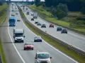 Ruch na autostradzie, gdzie samochody jadą różnymi pasami. Pytanie, czy na autostradzie można wyprzedzać z prawej strony, jest kluczowe dla bezpieczeństwa.