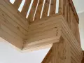 Detalles de la escalera con molduras de madera en la pared, creando un acabado rústico y acogedor.