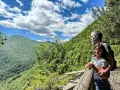 Un uomo e una bambina ammirano il panorama sui sentieri di Roccaraso, immersi nel verde lussureggiante delle montagne.