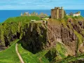 Ruiny zamku Dunnottar na klifie w Szkocji, majestatycznie górujące nad błękitnym morzem.