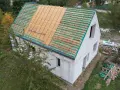 Budowa projektu domu 30m2 w trakcie. Widoczna konstrukcja dachu z łatami.