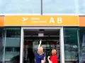 Dwie kobiety patrzą na tablicę "Odlocoty A B" na Lotnisku Chopina. Zastanawiają się, ile kosztuje parking na lotnisku Chopina.