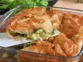 Una fetta di torta salata con zucchine, con croccante pasta sfoglia dorata e ripieno filante.