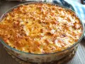 Macarrones al horno dorados y burbujeantes en una fuente de cristal, listos para servir.