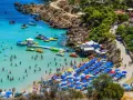 Piękna plaża na Cyprze, pełna ludzi kąpiących się i opalających. Czy na Cypr potrzebny jest paszport z Polski? Nie, wystarczy dowód osobisty.