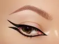 Occhio con un audace **reverse eyeliner** nero, che incornicia la palpebra inferiore e si estende verso l'alto, creando un look grafico e sofisticato.