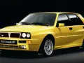 Żółta Lancia Delta Integrale HF z lat 90. na czarnym tle, z charakterystycznym grillem i felgami.