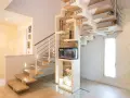 Moderna scala interna in legno e metallo, con acquario integrato e decorazioni in pietra. Un esempio di design che valorizza il costo scala interna.