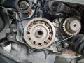 Zbliżenie na mechanizm silnika, widoczne koła zębate i pasek rozrządu. Czas na wymianę rozrządu!