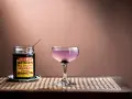 En elegant aviation drink med en burk Luxardo maraschino-körsbär, redo att förhöja smaken.