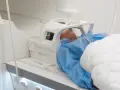 Pacjent leży w aparacie do rezonansu magnetycznego. Czas badania, czyli ile trwa rezonans głowy, zależy od wielu czynników.