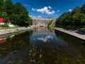 Zapora Pilchowice trasa. Malownicza droga nad zbiornikiem wodnym, z widokiem na monumentalną budowlę i otaczającą zieleń.