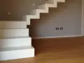 La larghezza scala interna è ben definita da gradini bianchi e minimalisti che salgono verso l'alto.