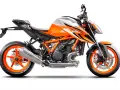 Pomarańczowo-biały motocykl KTM 1290 Super Duke R z agresywnymi grafikami i pomarańczowymi felgami.