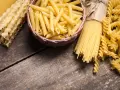 Różne rodzaje makaronu: penne, spaghetti, fusilli i faliste tagliatelle. Wybór między makaronem grahan a durum zależy od preferencji.