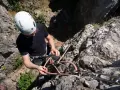 Mężczyzna w kasku przygotowuje się do wspinaczki. To idealne miejsce na wspinaczkę dla początkujących, z linami i sprzętem w gotowości.
