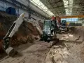 Koparki pracują w hali, przygotowując teren. Trwa wymiana gruntu, cena za m3 jest kluczowa dla budżetu.