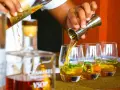 Ein Barkeeper gießt bernsteinfarbenen Rum in Gläser mit Eis und Minze. Die Frage "ab wann brennt Schnaps" wird hier durch das Servieren von edlem Rum beantwortet.