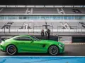 Zielony Mercedes GTR na torze wyścigowym, gotowy do jazdy. Za nim puste trybuny stadionu.