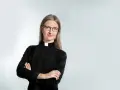 Eine Frau mit Brille und Kragen, die zeigt, dass Pfarrer Beamte sind.