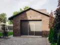 Nowy garaż na zgłoszenie, z cegły, z drzwiami i bramą segmentową. Obok plac zabaw.