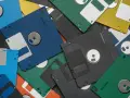 Montón de disquetes de colores, algunos con etiquetas blancas. Recuerdos de los juegos antiguos pc.