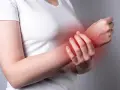 Osoba odczuwa ból nadgarstka przy zginaniu, co sugeruje zaczerwienienie w tej okolicy.