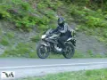 Motocyklista pokonuje zakręt na przełęczy Przysłup, otoczony zielenią górskich zboczy.
