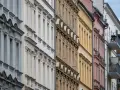 Reihenhausfassaden in verschiedenen Farben, von Grau über Beige bis Rosa. Ein Blick auf den m2 preis wohnung in dieser Gegend.