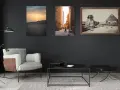Trois tableaux sur un mur sombre : un coucher de soleil sur les dunes, une personne marchant dans un temple égyptien, et le Sphinx et les pyramides. La **couleur référence** de la pièce est le gris anthracite.