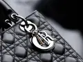 Elegancka, pikowana torebka Lady Dior w kolorze czarnym, z metalicznym logo Dior.