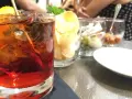 Orzeźwiający drink z lodem i cytryną, obok chipsy i oliwki. Idealne połączenie, by dowiedzieć się, **sambuca z czym pić**.