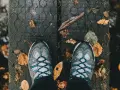 Scarpe in Gore-Tex donna pronte per un'avventura autunnale su un ponte di legno coperto di foglie.