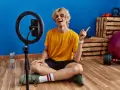 Joven influencer de fitness sonríe y señala, listo para grabar sus acciones con influencers.