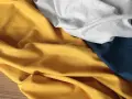 Miękkie tkaniny w kolorach musztardowym, szarym i granatowym. Czy poliester oddycha? Zależy od jego struktury.