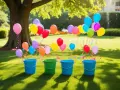 Färgglada ballonger svävar över hinkar på en gräsmatta, redo för en lek att kasta boll i hink.