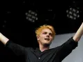 Gerard Way, Sänger des Musikgenres mit E, mit blonden Haaren und erhobenen Armen auf der Bühne.