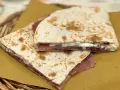 Piadine ripiegate con prosciutto e formaggio cremoso, semplici ingredienti piadina che creano un sapore delizioso.