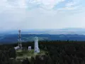 Wieża widokowa niczym wielka sowa, ile się wchodzi, góruje nad lasem. Obok maszt telekomunikacyjny.