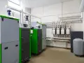 Pomieszczenie techniczne z kotłami, rurami i manometrami.