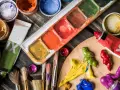 Palette de couleurs vives pour une peinture à l'acrylique. Tubes de peinture, pinceaux et pots de couleurs sont prêts pour la création artistique.